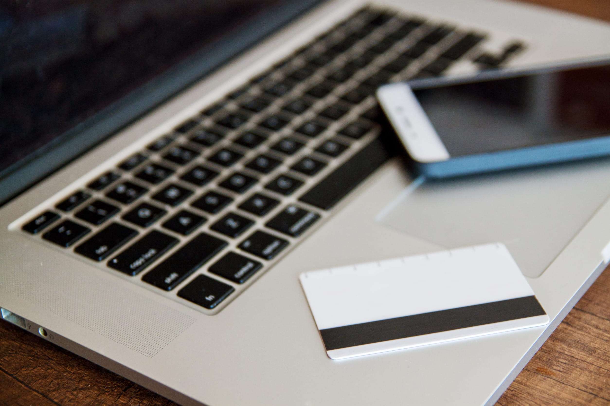 A Credit Card And A Phone Placed On A Laptop