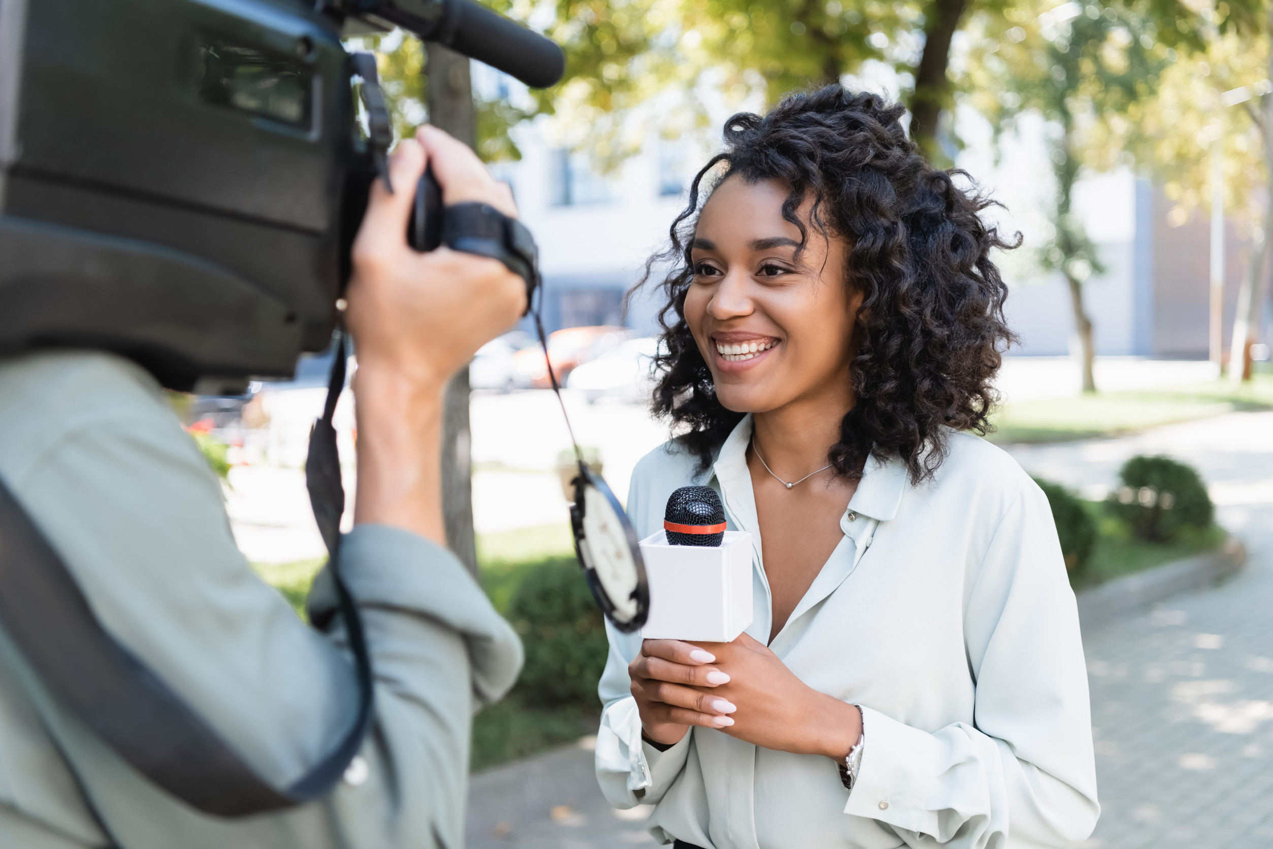 A journalist facing the camera and smiling