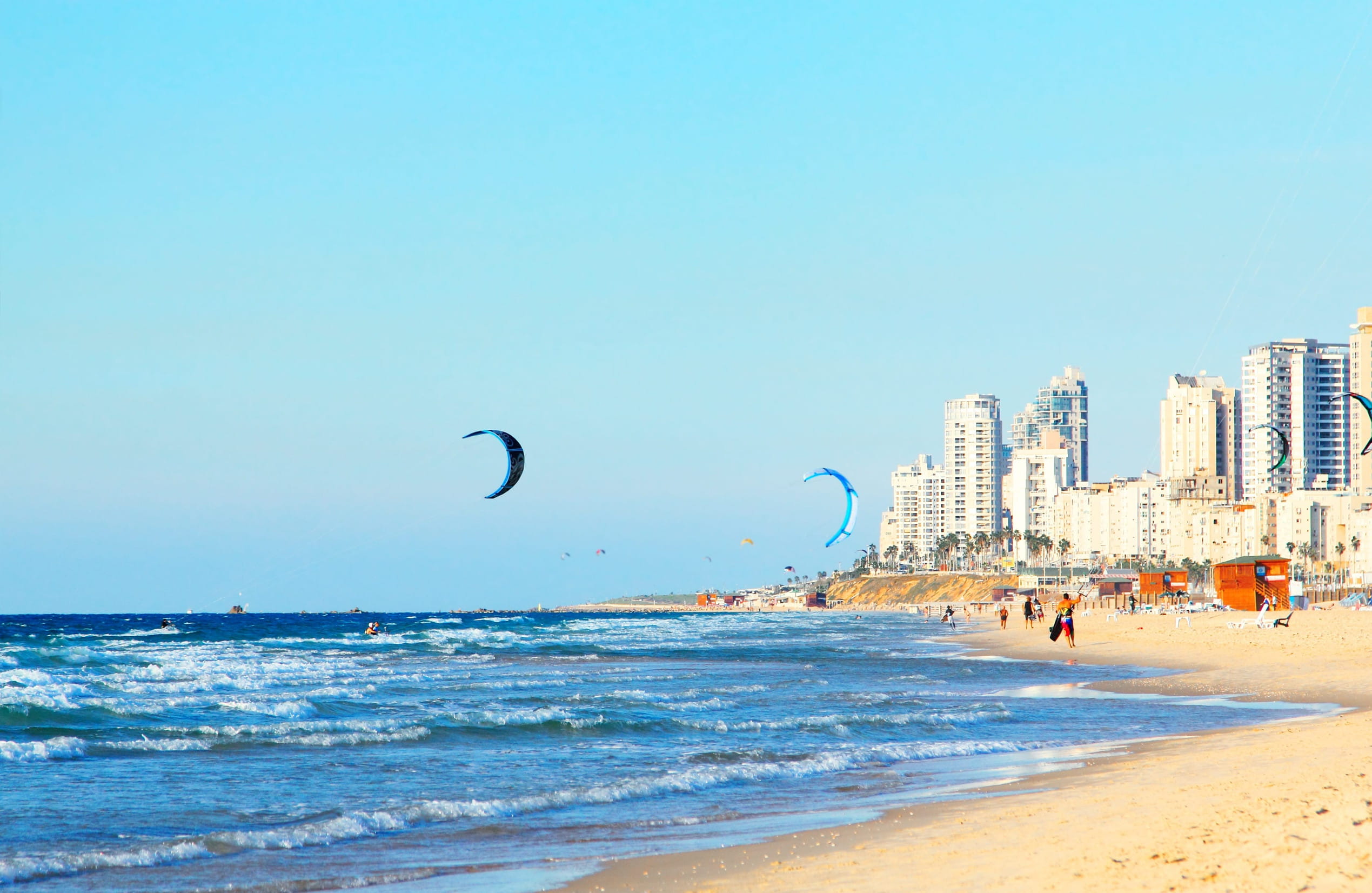 Israel coastline with people walking on sand